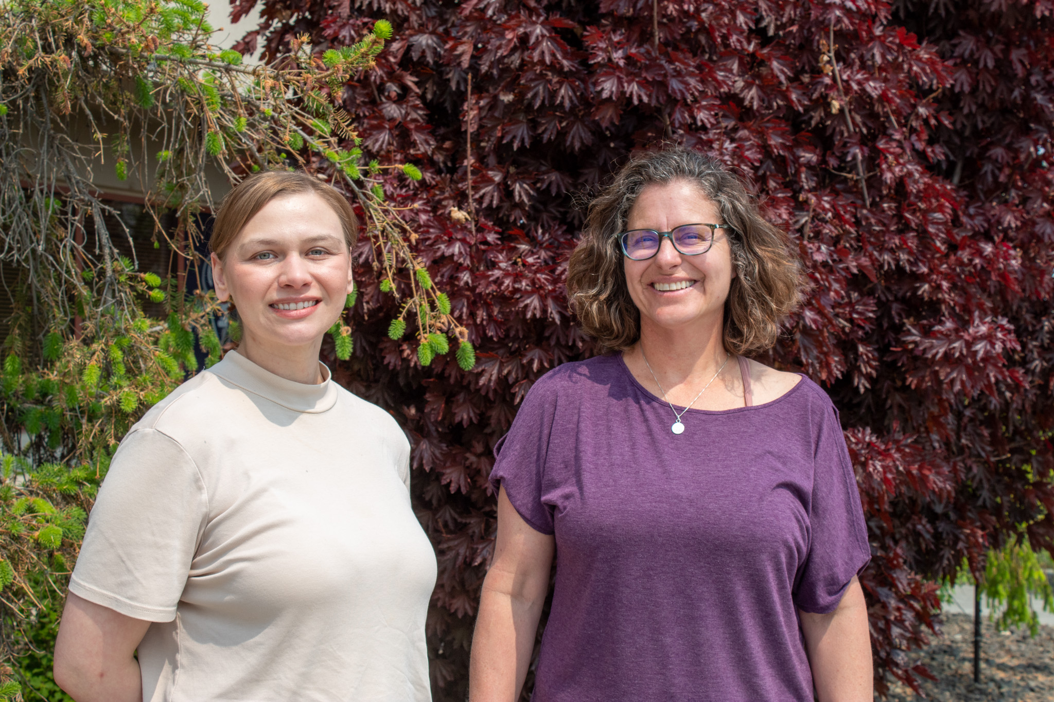 Sara Hupp, left and Dr. Barbara Ann Bush, right, pose in front of trees.